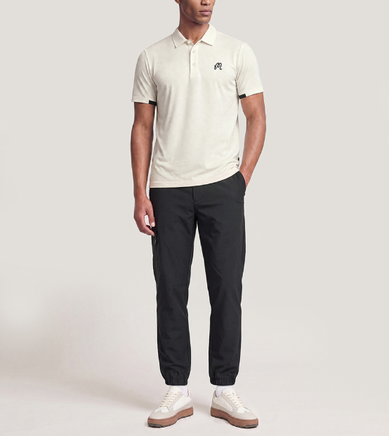 Model wearing Malbon men's beige dot print golf polo
