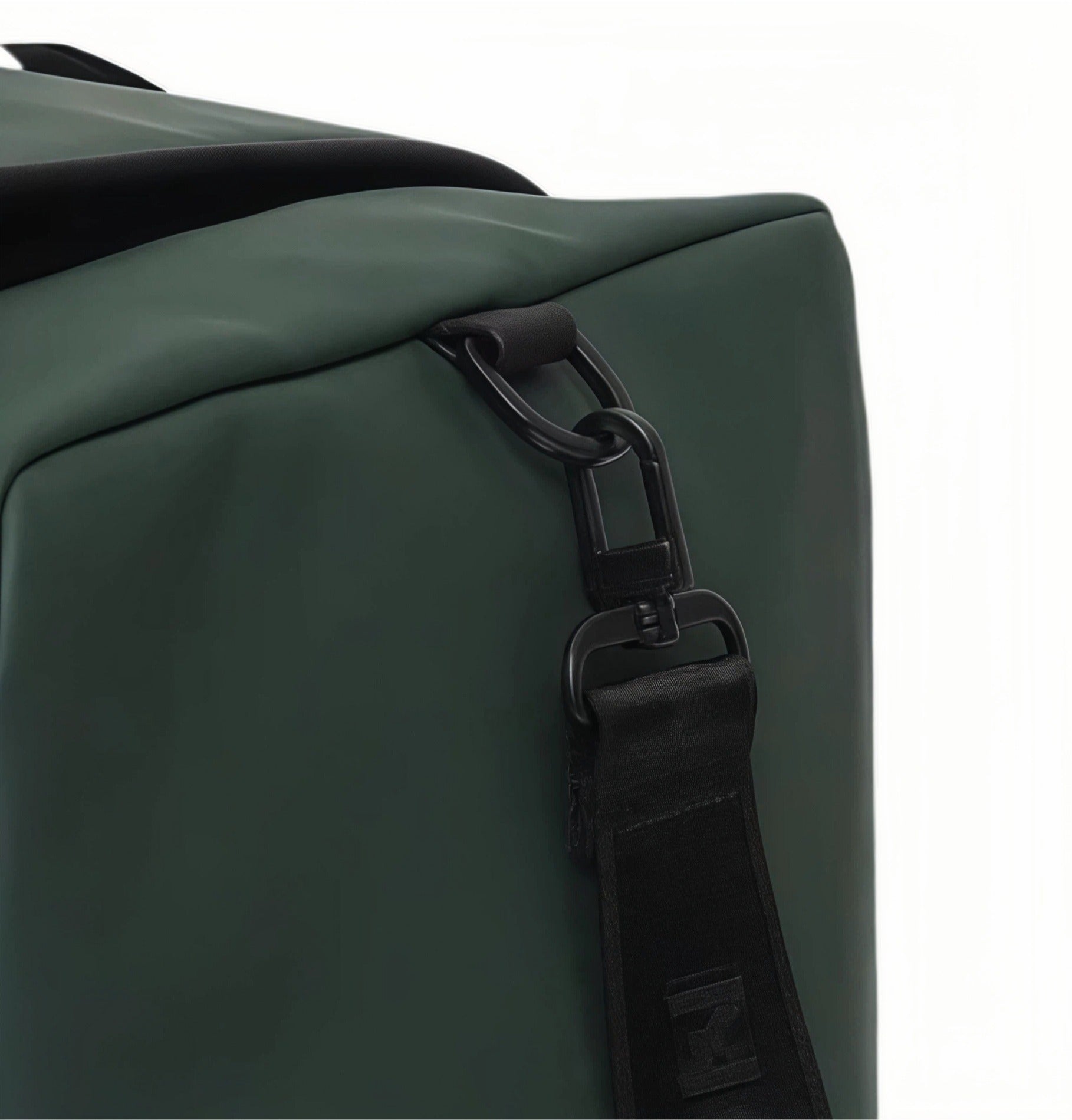 Detailed close-up of Malbon Golf duffle bag's side handle attachment showing reinforced black metal D-ring and durable webbing strap for secure carry