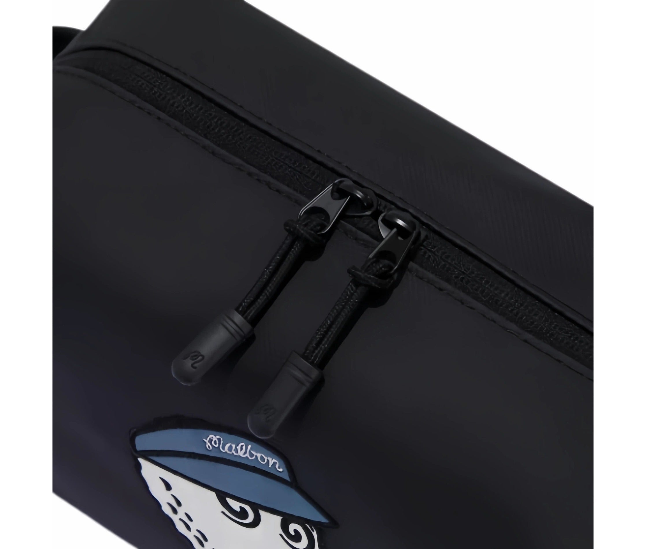 Close-up of black Malbon Golf mini handbag zipper with dual black pull tabs featuring embossed "M" logo, textured fabric, and clean white stitching