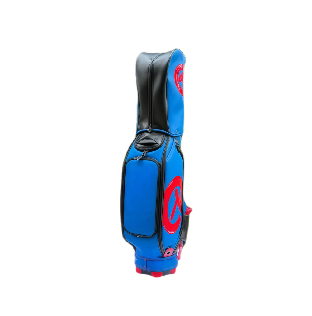 A side view of the Scotty Cameron Camo Collage Staff Bag in a striking blue and red colorway. The bag features a large, glossy red "Circle T" logo and black accents, showcasing its premium design and durable construction.
