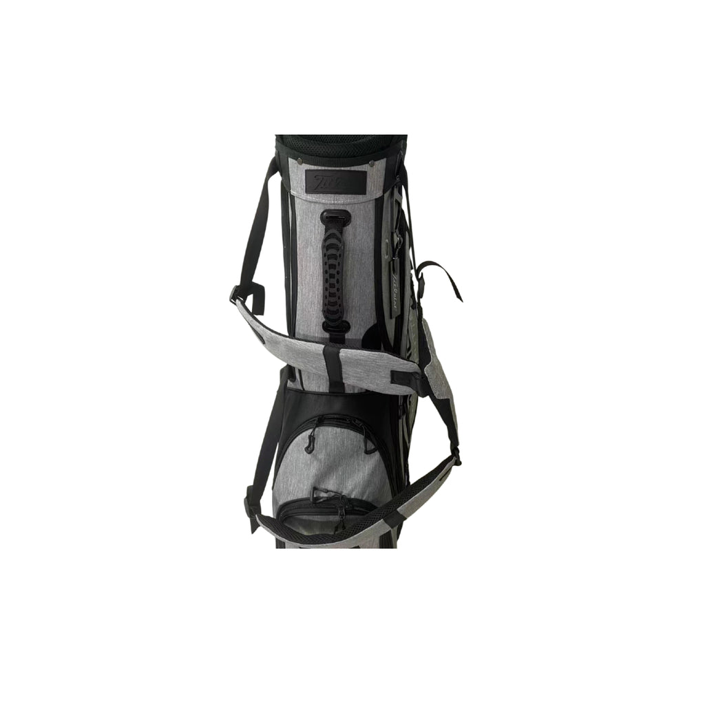 Front view of the Scotty Cameron Pathfinder Heather-Gray Stand Bag. Features premium heathered gray fabric, bold black "SCOTTY CAMERON" vertical branding, and the iconic Circle T logo on the side pocket. Includes a matching gray rain hood.