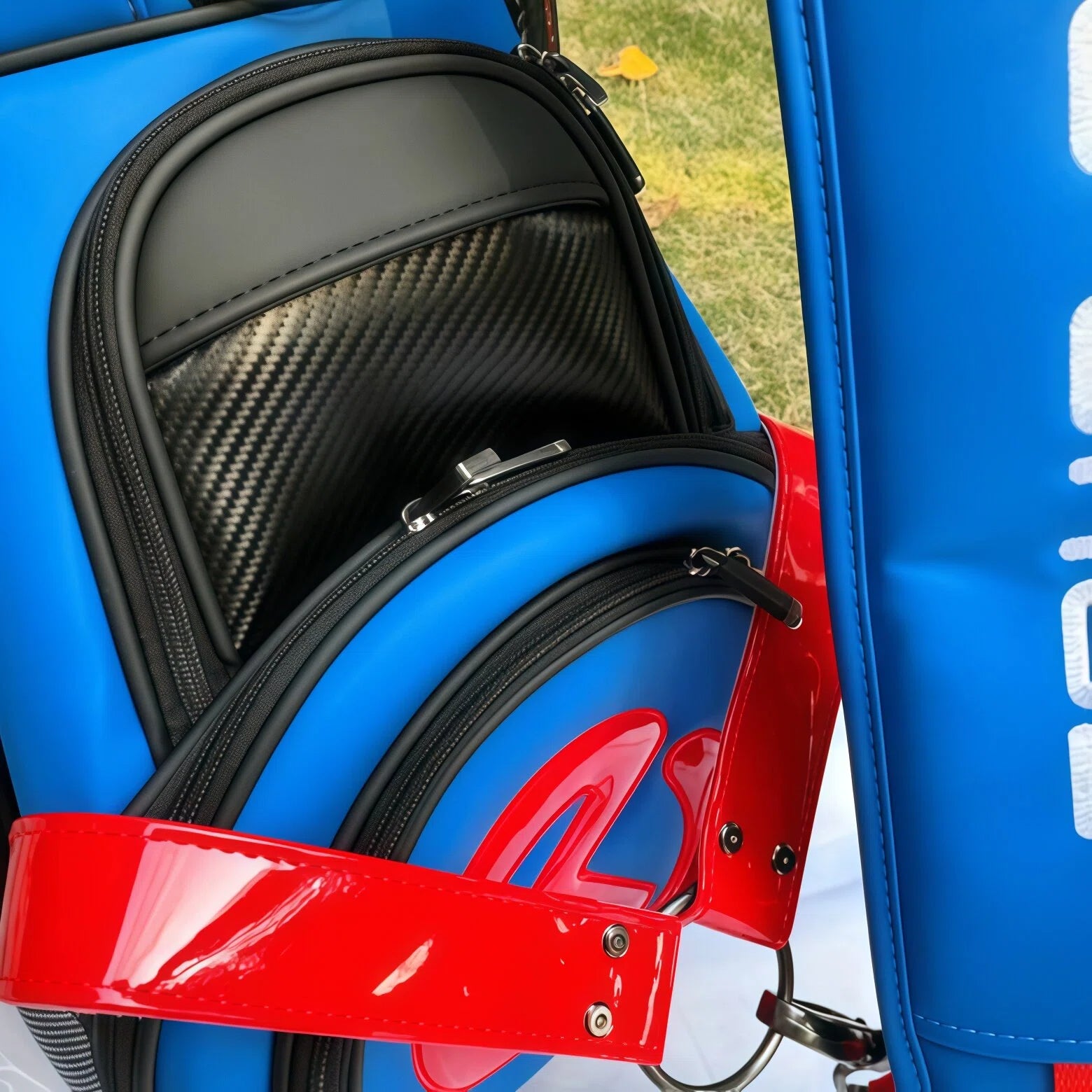 A close-up detail shot of the Scotty Cameron Staff Bag, showing the high-quality zippers and the premium carbon fiber texture on the pocket lining. The image emphasizes the bag's luxurious materials and craftsmanship.