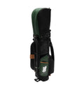 Side profile of Malbon Golf caddy bag showing embossed script logo, green accent panel with white 'HH MALBON' emblem, brown leather trim, and adjustable shoulder strap.