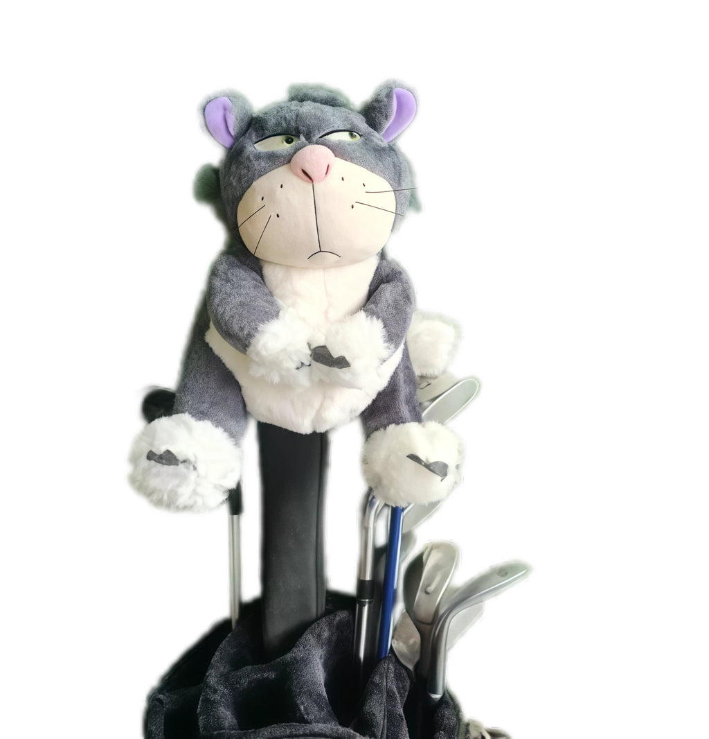 Front view of a plush gray and white cat golf headcover with purple ears, pink nose, and expressive eyes, sitting atop a driver shaft inside a black golf bag among other clubs.