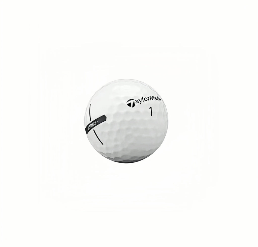 Close-up of TaylorMade Distance+ golf ball featuring the alignment aid stripe, brand logo, and number 1 marking, designed for high velocity and low drag performance.