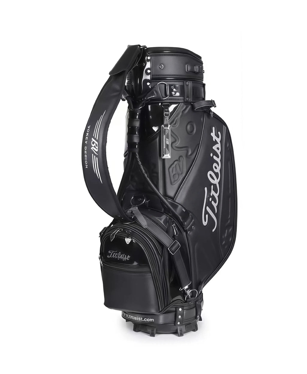 Full view of the Titleist Heritage Cart Bag in black glossy finish. Features the "Titleist" script logo in silver, padded shoulder strap with "Vokey Design" text, and multiple zippered compartments. Built for durability and elegance.