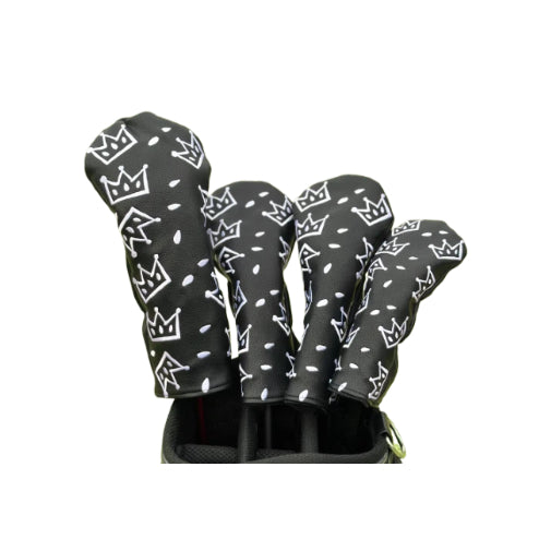 Black Waac golf headcover set with white crown pattern, shown installed on clubs inside golf bag; high-contrast design for visibility and style during night play or low-light conditions.